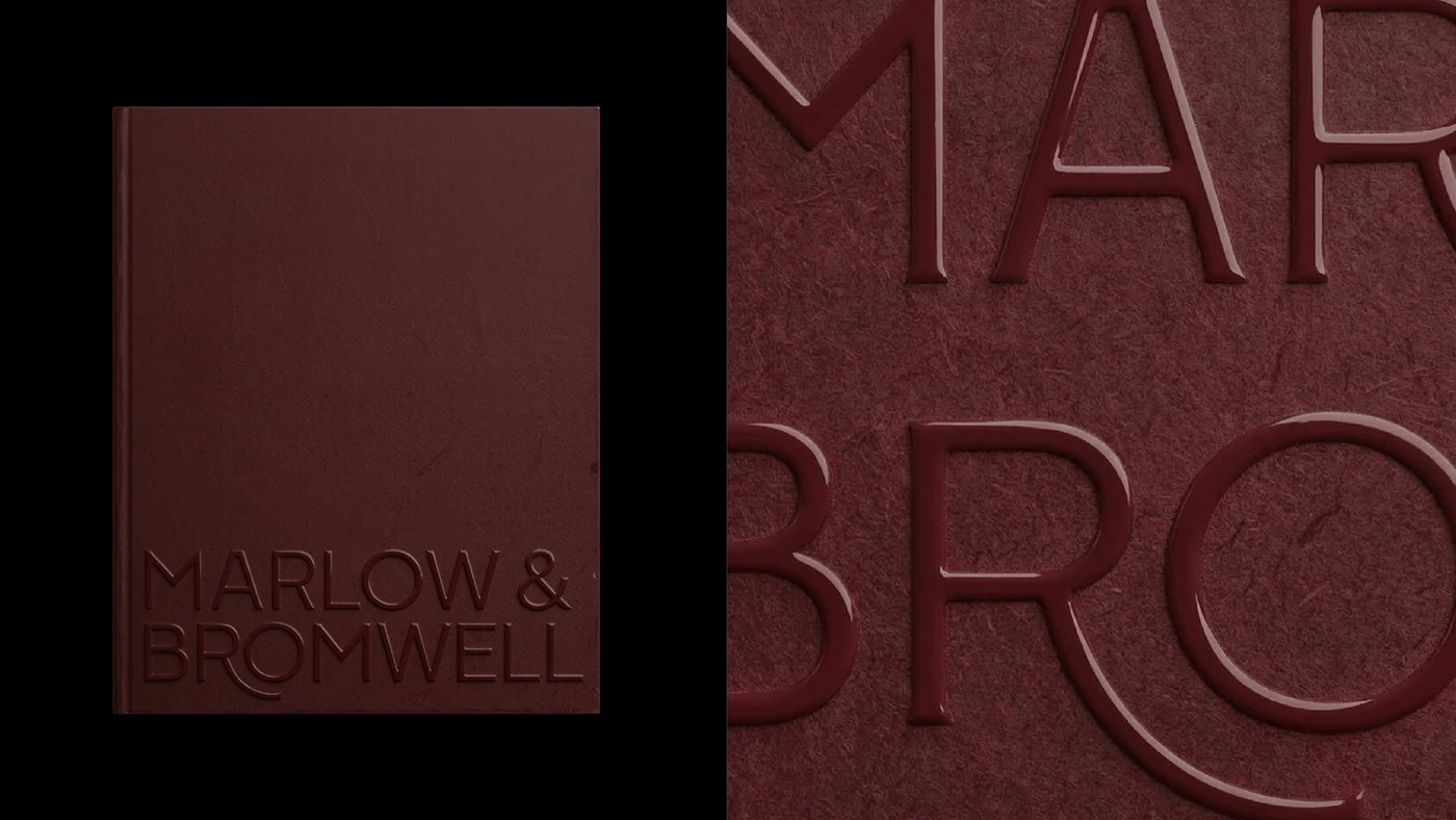 Marlow & Bromwell Manor brand identity close-up showing debossed leather book cover and deep burgundy embossed typography detail