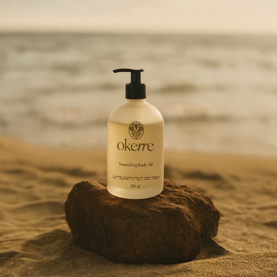 Okerre nourishing body oil bottle styled on a natural rock at the beach, highlighting minimal premium skincare packaging and nature-inspired brand positioning.