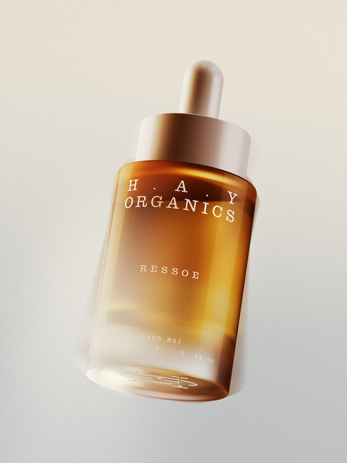 HAY Organics Ressoe amber dropper bottle with minimal white typography, frosted glass effect, and a soft neutral background.