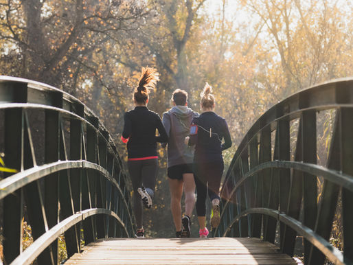 Three runners crossing a bridge