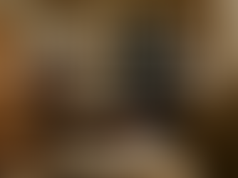 A serene, horizontal photograph shows an African-American woman sitting in bed with natural light pouring in through the window. She is journaling with a soft expression of focus and reflection. A warm cup of tea rests nearby on a wooden tray. The scene evokes stillness, gratitude, and inner healing. Overlaid text reads: “Gratitude Is Inner Work: Learning to See the Good in What Didn’t Feel Good.”