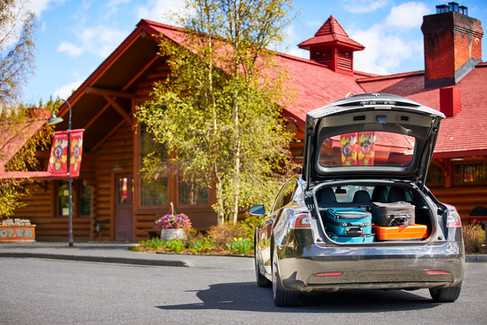 A Tesla Model S parked outside a hotel in Lake Louise, Alberta, with it's hate open and luggage visible, By Jeff B Photography