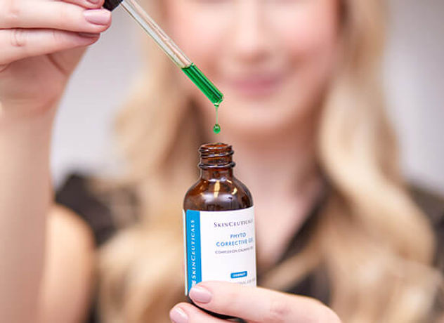 Branding image of a woman holding a dropper of skin serum