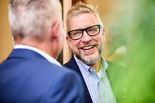 Candid photo of two gentlemen laughing at a corporate event.