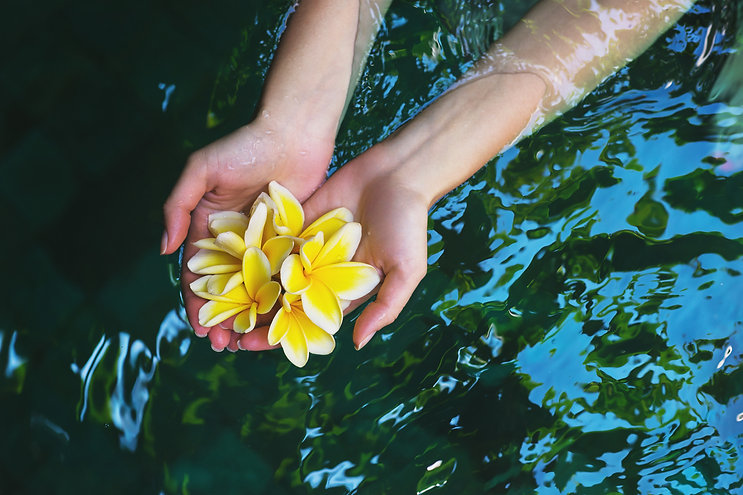 Woman holiding tropical flowers to represent reiki healing in Hawaii.