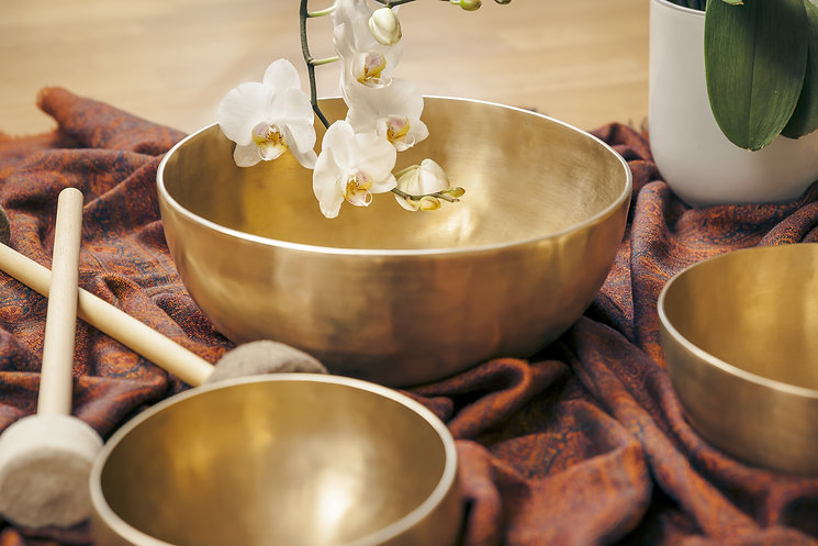 Singing bowl with orchids representing sound healing in Hawaii.