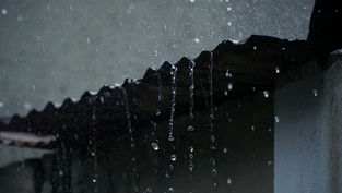 Mauvais écoulement des eaux de pluie sur une maison en Guadeloupe avec façade et sols humides.