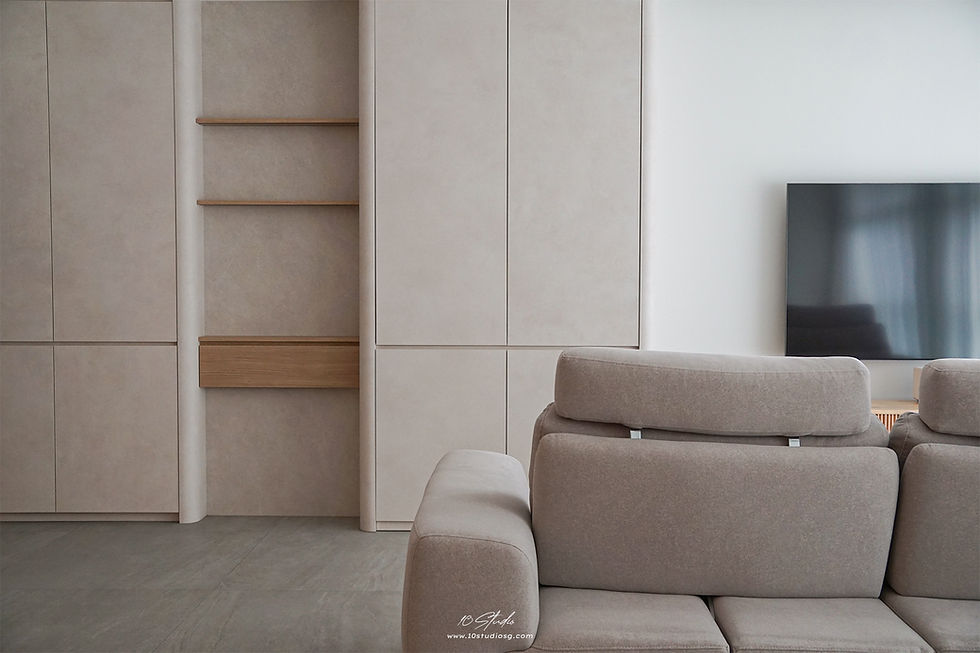 Luxurious bathroom with marble walls and floor, an oval mirror, sink, and wall-hung toilet. Soft lighting creates a serene ambiance.