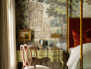 A professional interior designer and a client collaborating in a beautifully designed living room, reviewing fabric swatches and design plans.