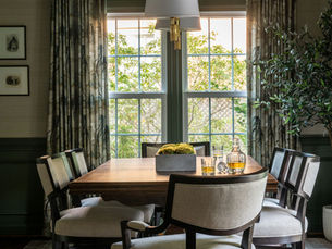 A stylish dining room with a bold green ceiling, complemented by neutral walls, a modern dining table, and elegant decor accents.