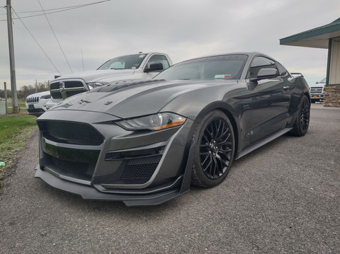A grey sports car parked in front of a building