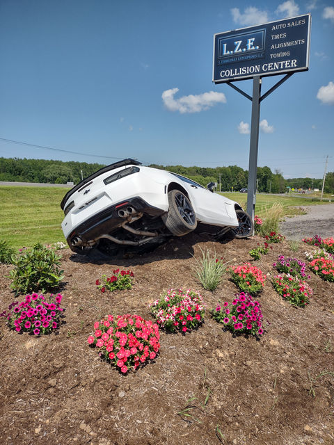 A car that is upside down in the dirt