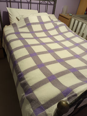 Beautiful double thickness knitted blanket shown on a double bed.