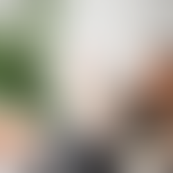 Woman procrastinating at her desk with feet up, holding a paper airplane while work materials sit untouched, illustrating procrastination and task avoidance at work.