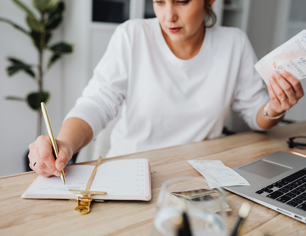 Woman budgeting at a desk with receipts, planner, and laptop. Represents women managing finances, smart money habits, budgeting confidence, and financial wellness in real life.
