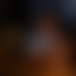 A woman winding down for the night, sitting in bed under a soft blanket, reading by warm lamp light as part of her evening self-care routine.