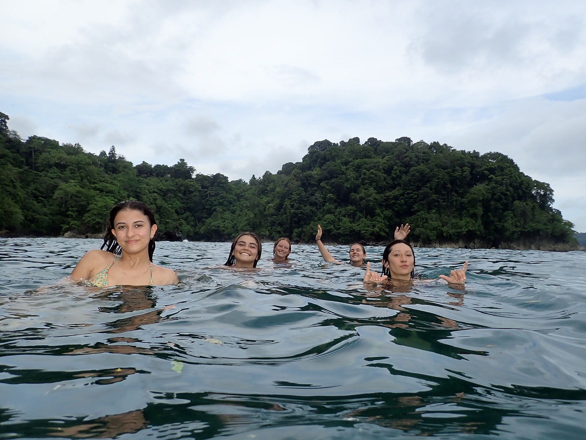 Alana and friends in the ocean waiving