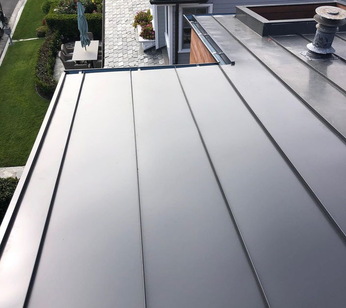 A view of a newly installed metal roof with custom rain and morning dew collectors, showcasing a blend of modern design and sustainable functionality.