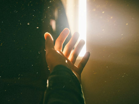 "A hand reaching toward bright light, symbolizing hope, healing, and personal transformation."