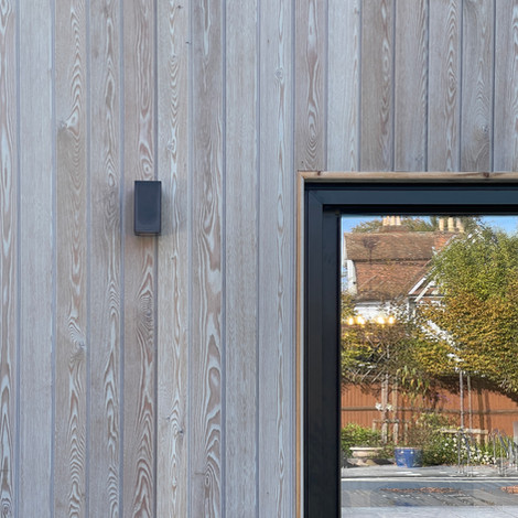 Wooden cladded house with a window
