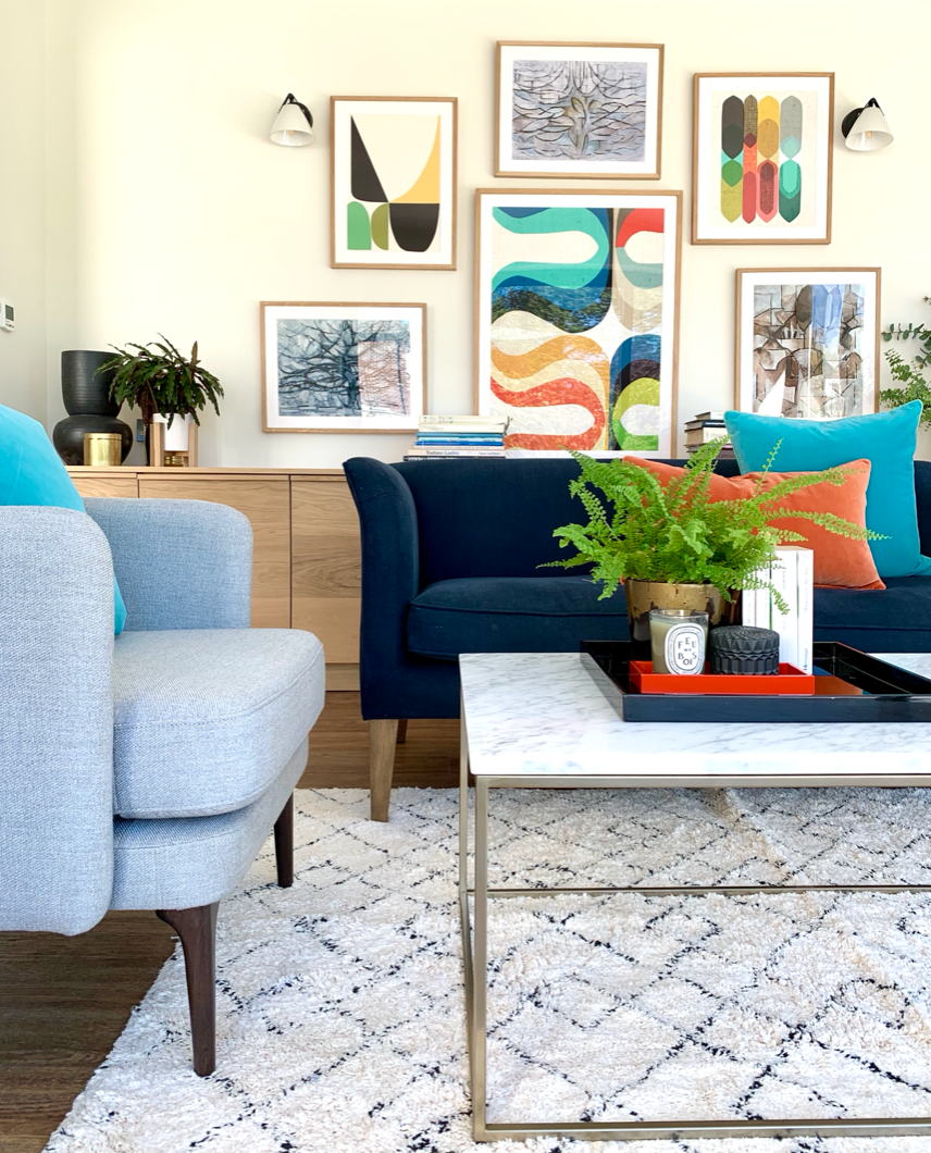 Modern Picture wall. Oak side table. Navy Velvet sofa. Vintage moroccan rug.