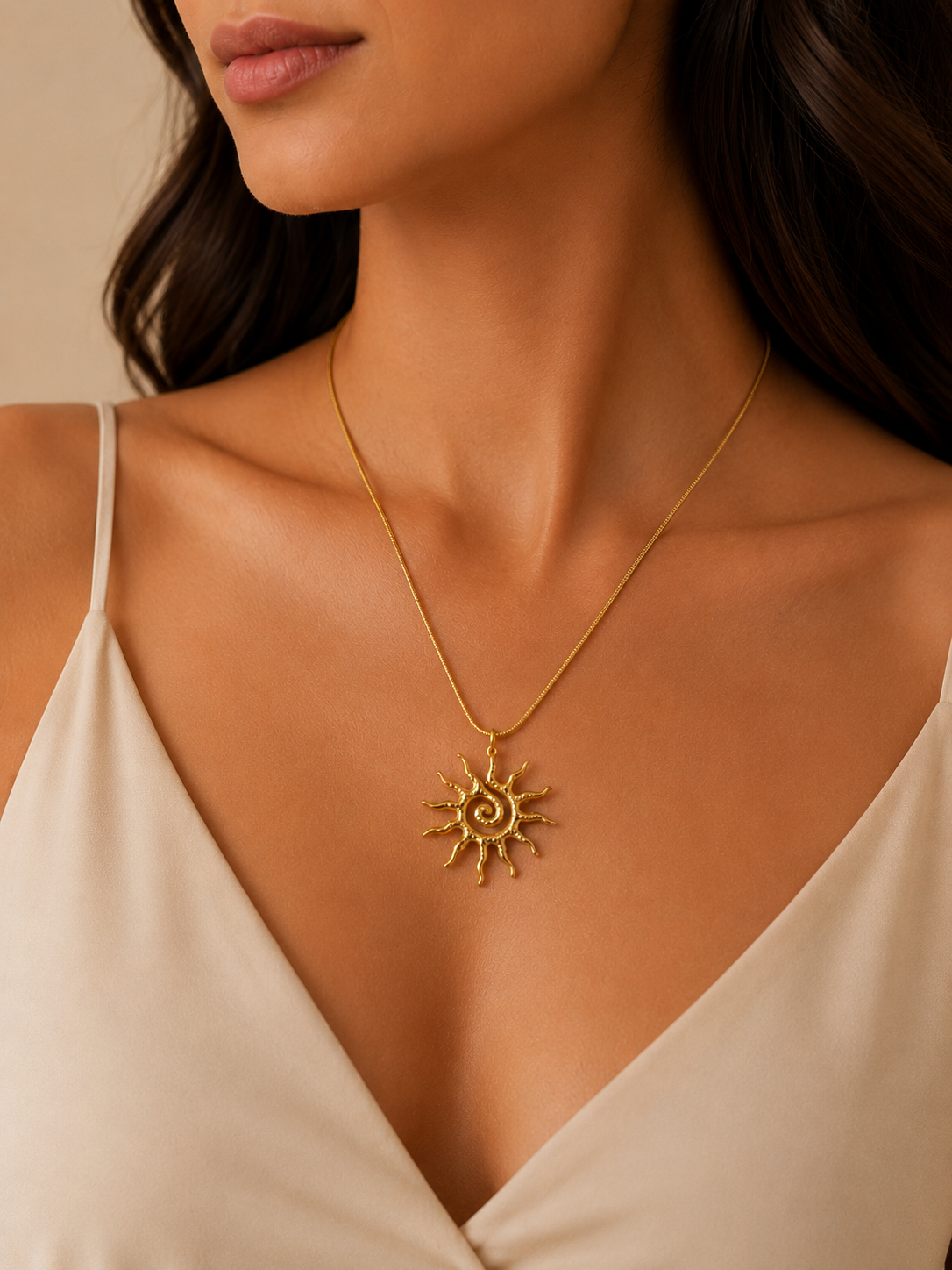 Model wearing a gold sunburst pendant necklace with celestial-inspired design