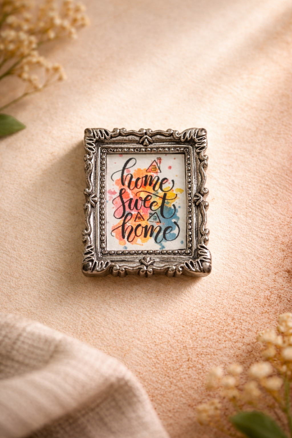 Vintage frame fridge magnet with “home sweet home” text and colorful artwork on a warm background