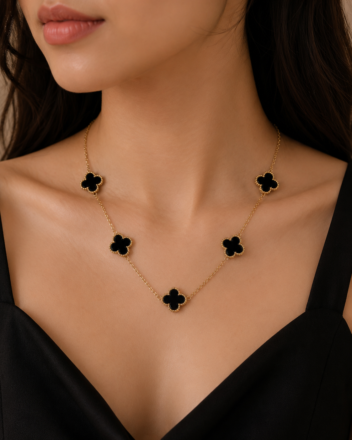 Model wearing Noir Clover Luxe Necklace with black clover charms and gold plated chain in luxury jewellery styling.