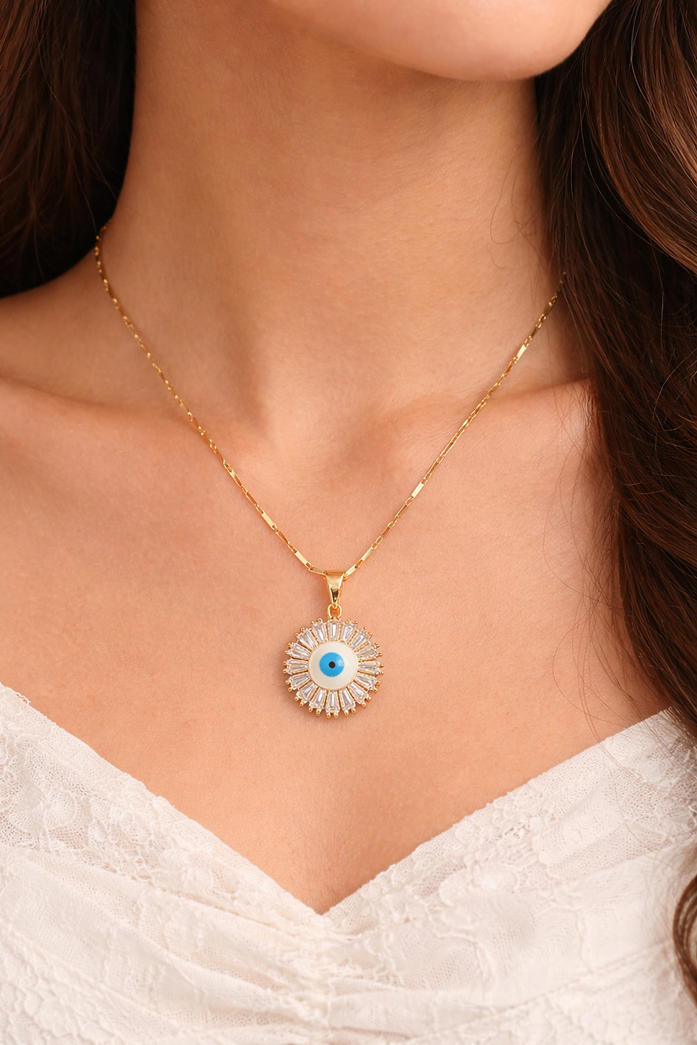 Gold Aurora Nazar Necklace with sparkling baguette crystal detailing and evil eye pendant worn by a model in a white outfit.