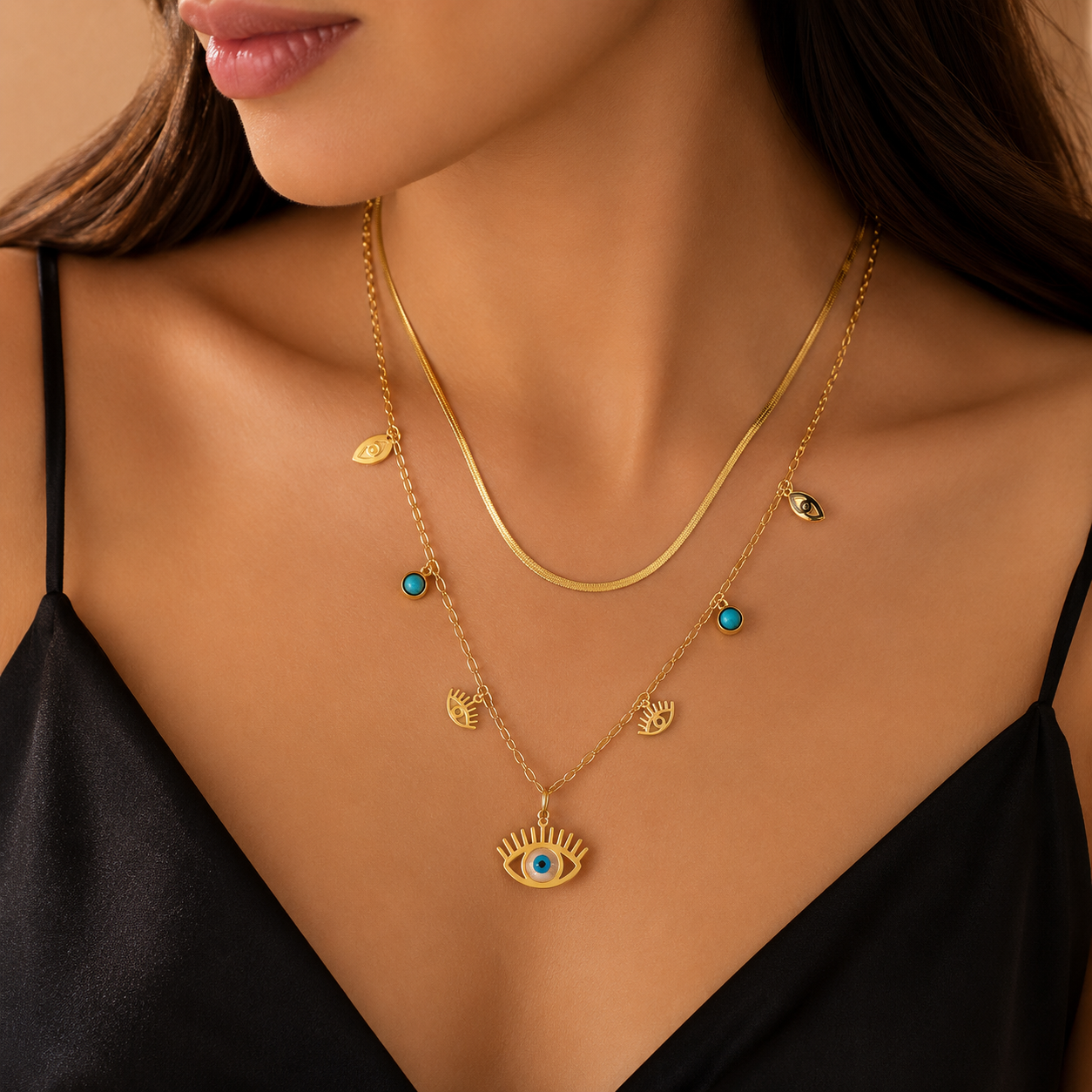Model wearing layered gold evil eye necklace with turquoise accents and luxury black satin styling