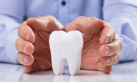 Man's Hand Protecting Healthy Hygienic White Tooth On Reflective Table_edited.jpg