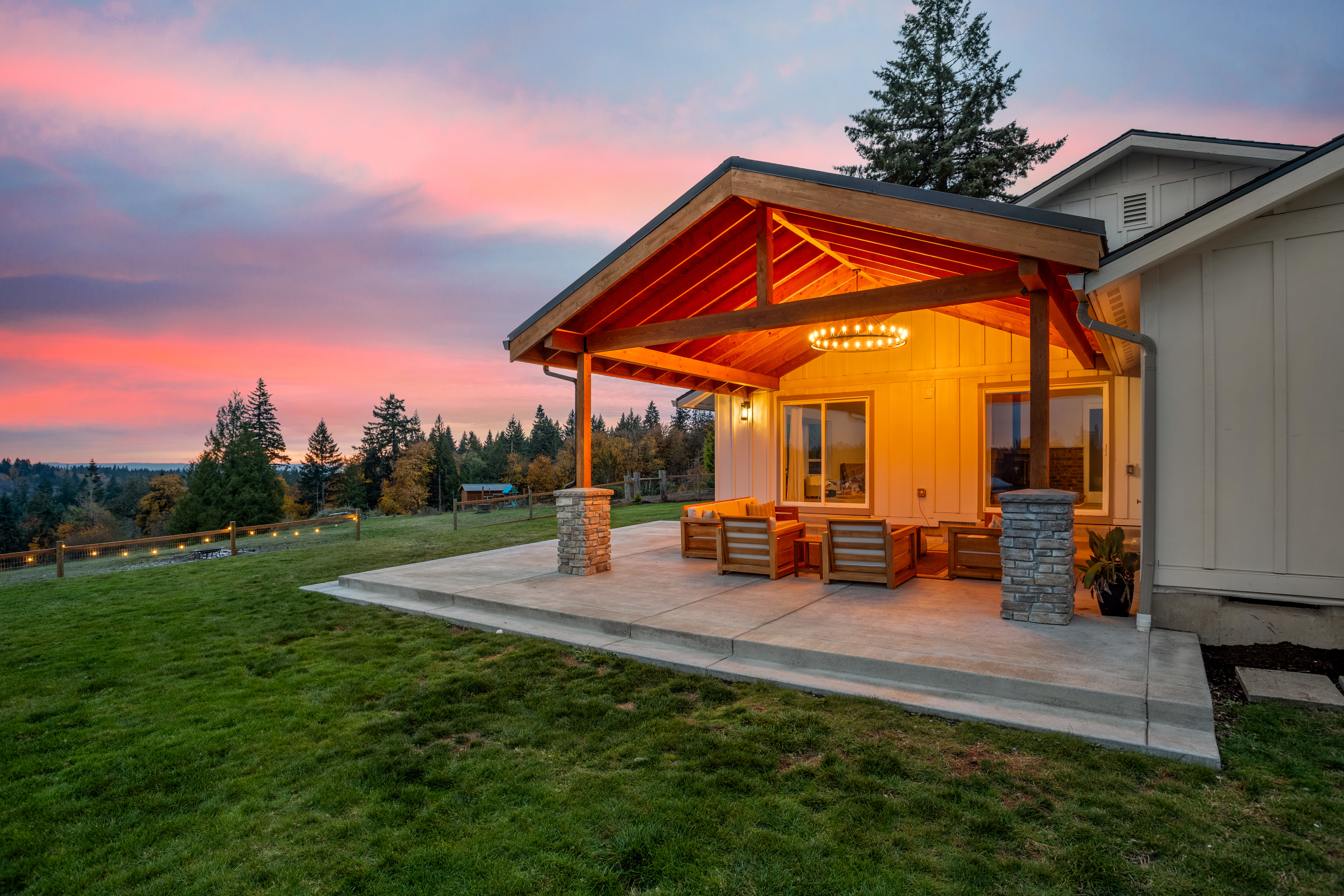 Illuminated covered patio at sunset with outdoor furniture