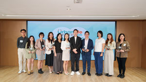 Ten people pose with glass awards in a conference room before a blue UrbanLife health backdrop, smiling.