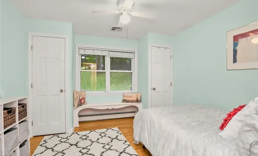 Before picture of boy's bedroom with bright, light cyan painted walls and white ceiling fan