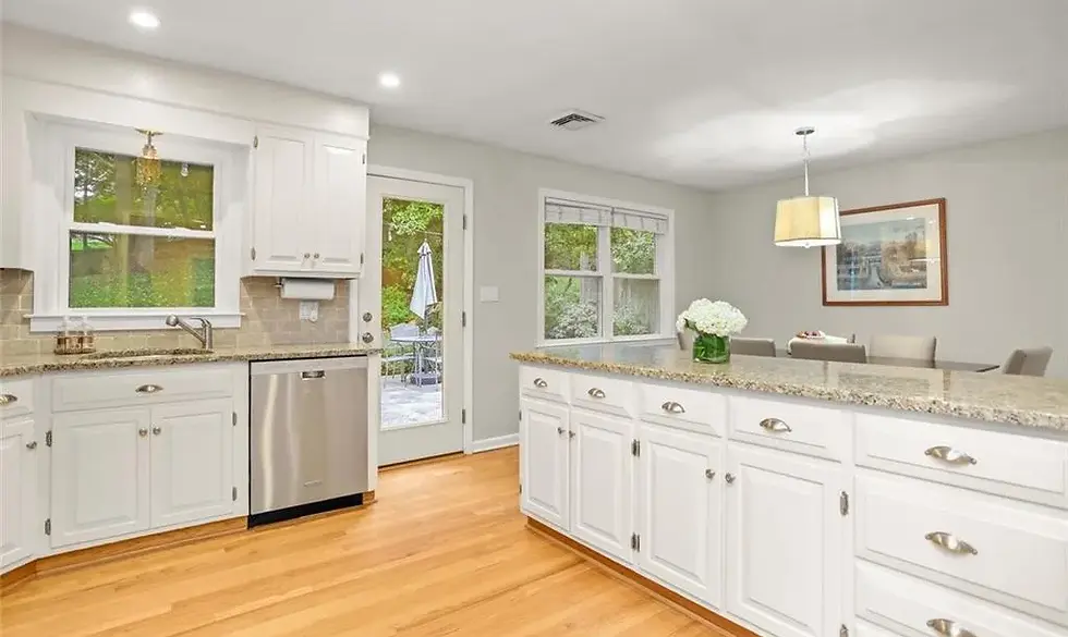 Angled picture of eat-in kitchen with light grey walls and pendant light in dining area