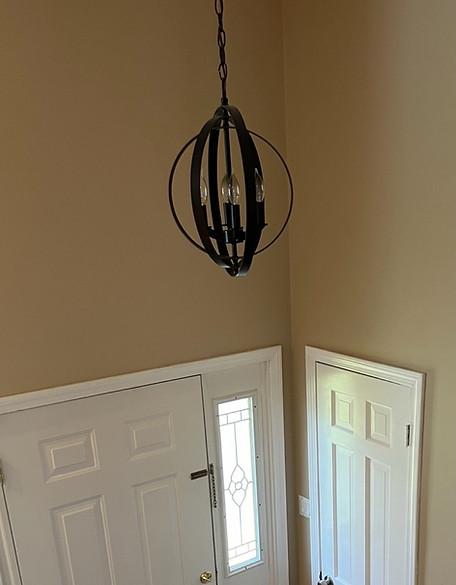 Before picture of foyer with dark beige paint and white interior doors