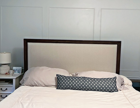 After picture closeup of picture frame moulding behind California king sized bed and side table