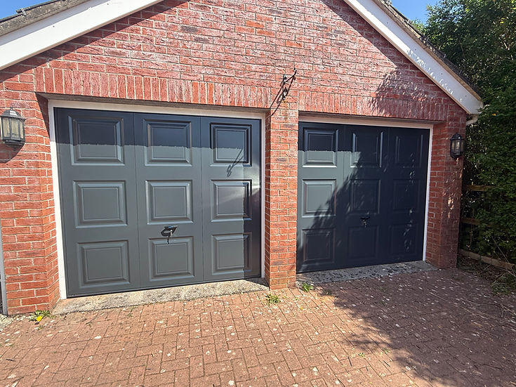 Red brick garage with two dark gray panel doors