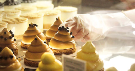person reaching towards a pastry