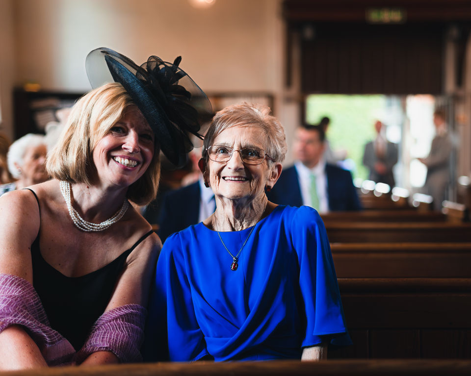 Family members gathered at a wedding ceremony, sharing smiles and celebrating the couple’s special day