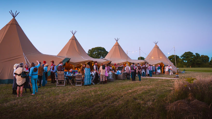 Outdoor wedding venue at sunset with golden light illuminating the surroundings, creating a romantic and serene atmosphere.