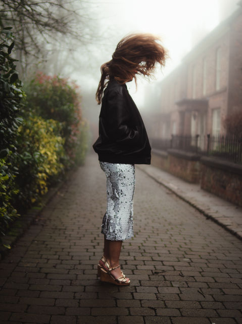 Portrait of a model in mid-air jump, wearing stylish attire and showcasing vibrant energy