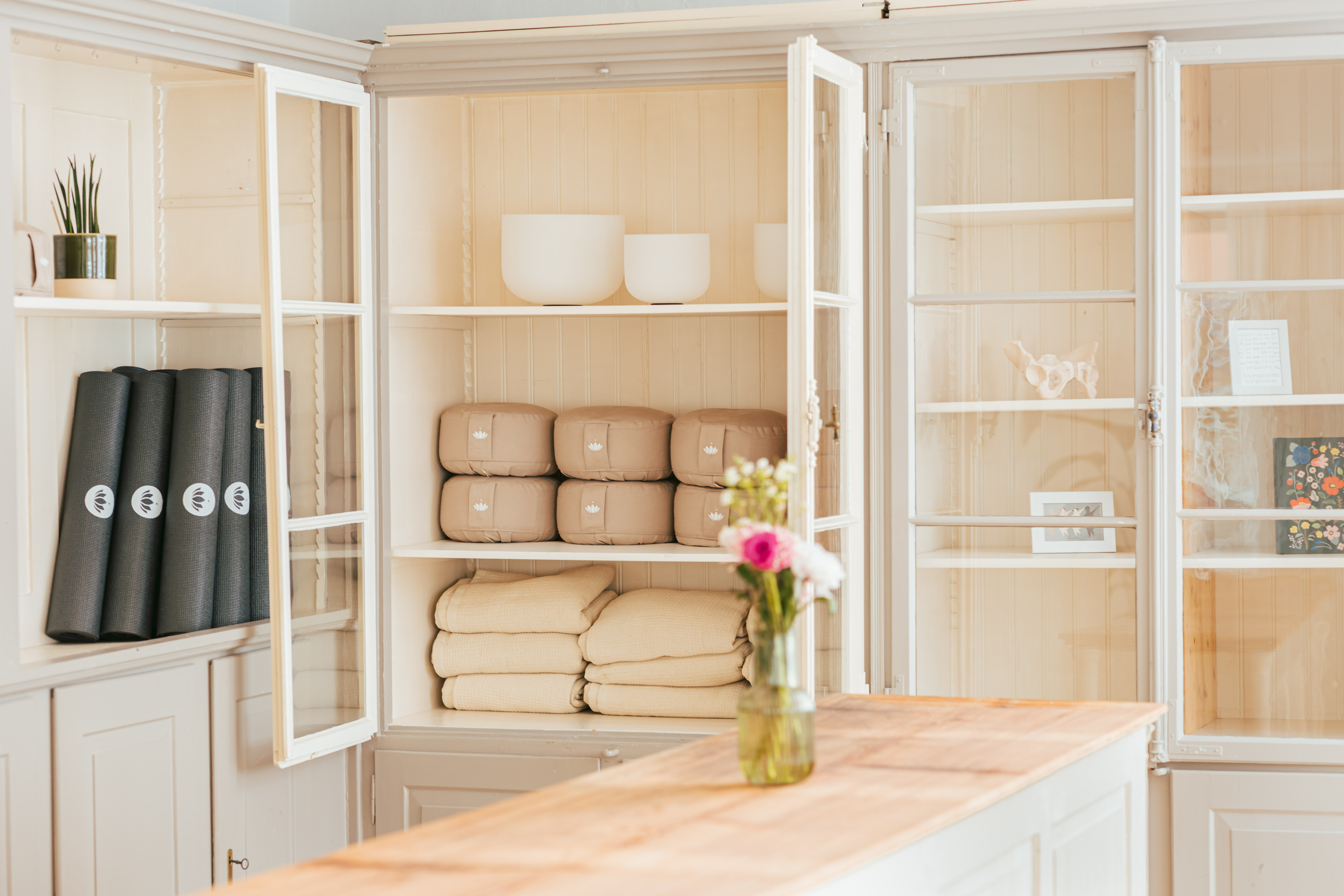 Räumlichkeiten mit Theke, Schrank und Yoga-Equipment