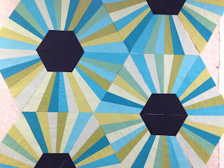 Multiple Magic Triangle Quilt Blocks arranged in a hexagon design, with dark centers.  