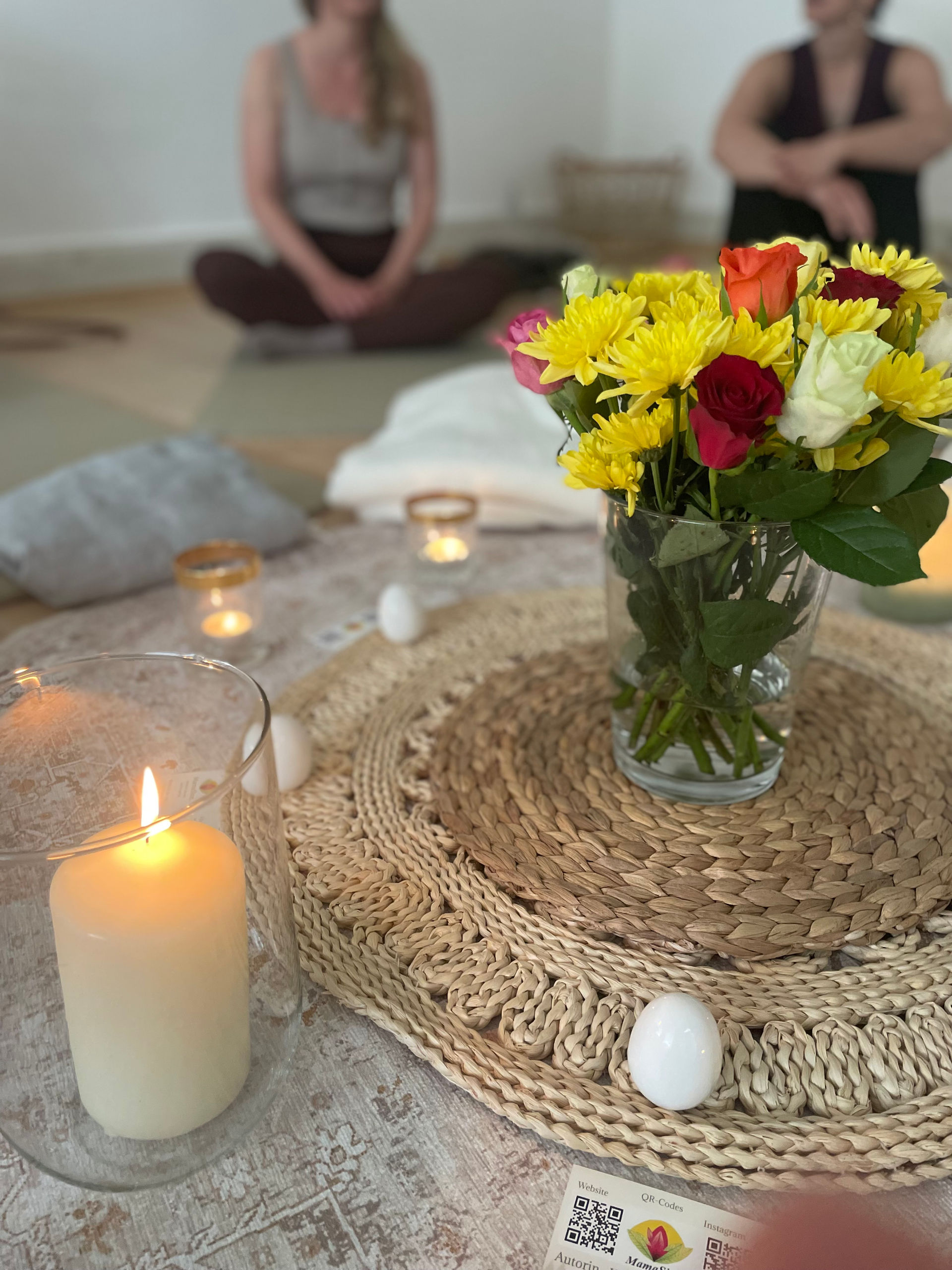 Stimmungsvolle Atmosphäre bei einer Veranstaltung im SORO Projekt mit Blumen, Kerzen und Sitzkreis.
