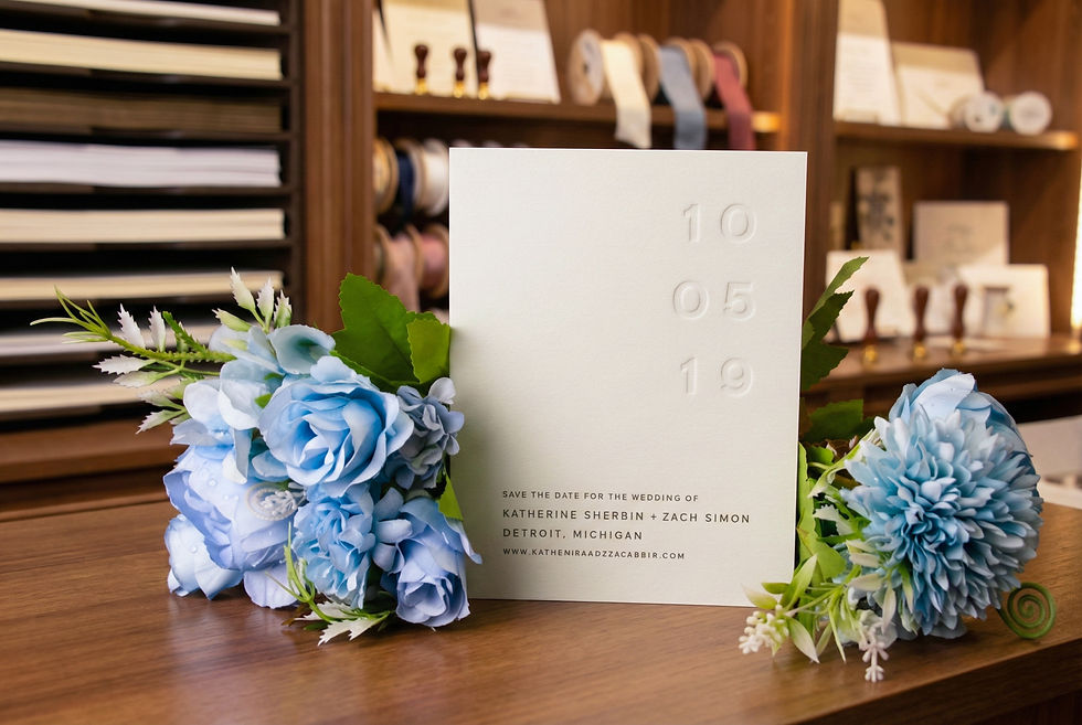 Close-up view of a custom letterpress invitation with intricate floral design on textured paper