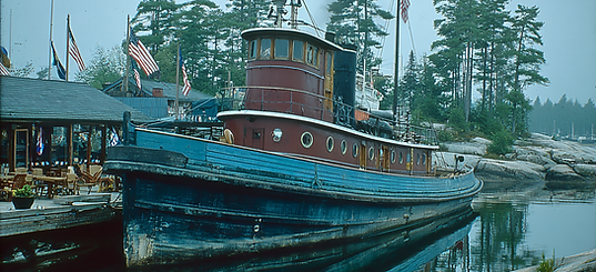 u1269451146_A_large_vintage_red-and-black_tugboat_docked_in_a_5b1134e2-b4f2-4a36-8a0c-6242
