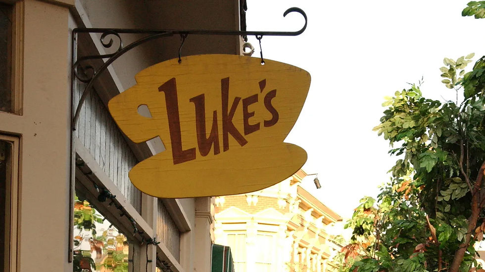 Stars Hollow'da yer alan ünlü Luke's Diner'ın tabelası, sonbaharın renkleriyle çevrelenmiş. Sararan yapraklar ve hafif esen rüzgarla, sabahın ilk ışıkları dükkânın camlarına vuruyor, kasaba sakinlerinin günlük rutini için huzurlu bir atmosfer oluşturuyor.
