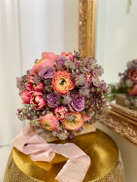 Bridal bouquet, colourful tulips, roses ranunculus used in it, in Biedermeier style.