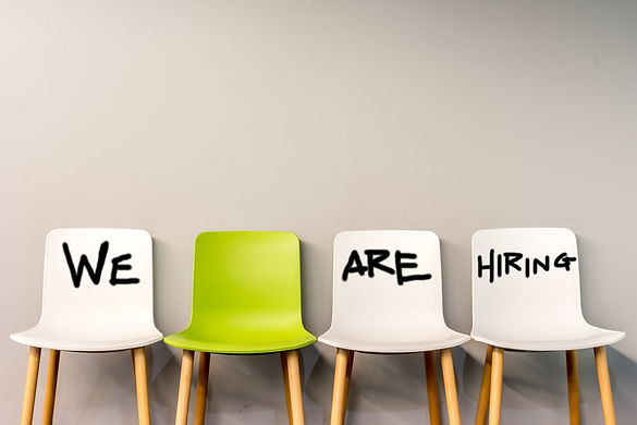 Job recruiting advertisement represented by 'WE ARE HIRING' texts on the chairs or wall. O